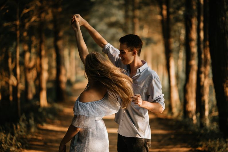 Romance - man and woman dancing at center of trees