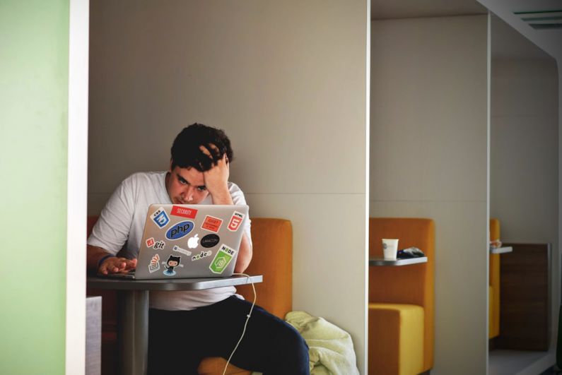 Financial Stress - man wearing white top using MacBook
