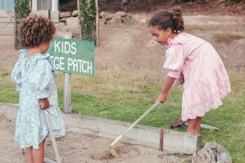 Kids - a couple of girls cleaning the ground