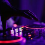Music - selective focus silhouette photography of man playing red-lighted DJ terminal