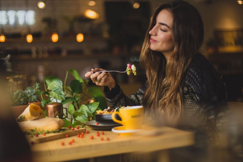 Mindful Eating - woman holding fork in front table