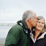 Anti-Aging - man kissing woman on check beside body of water